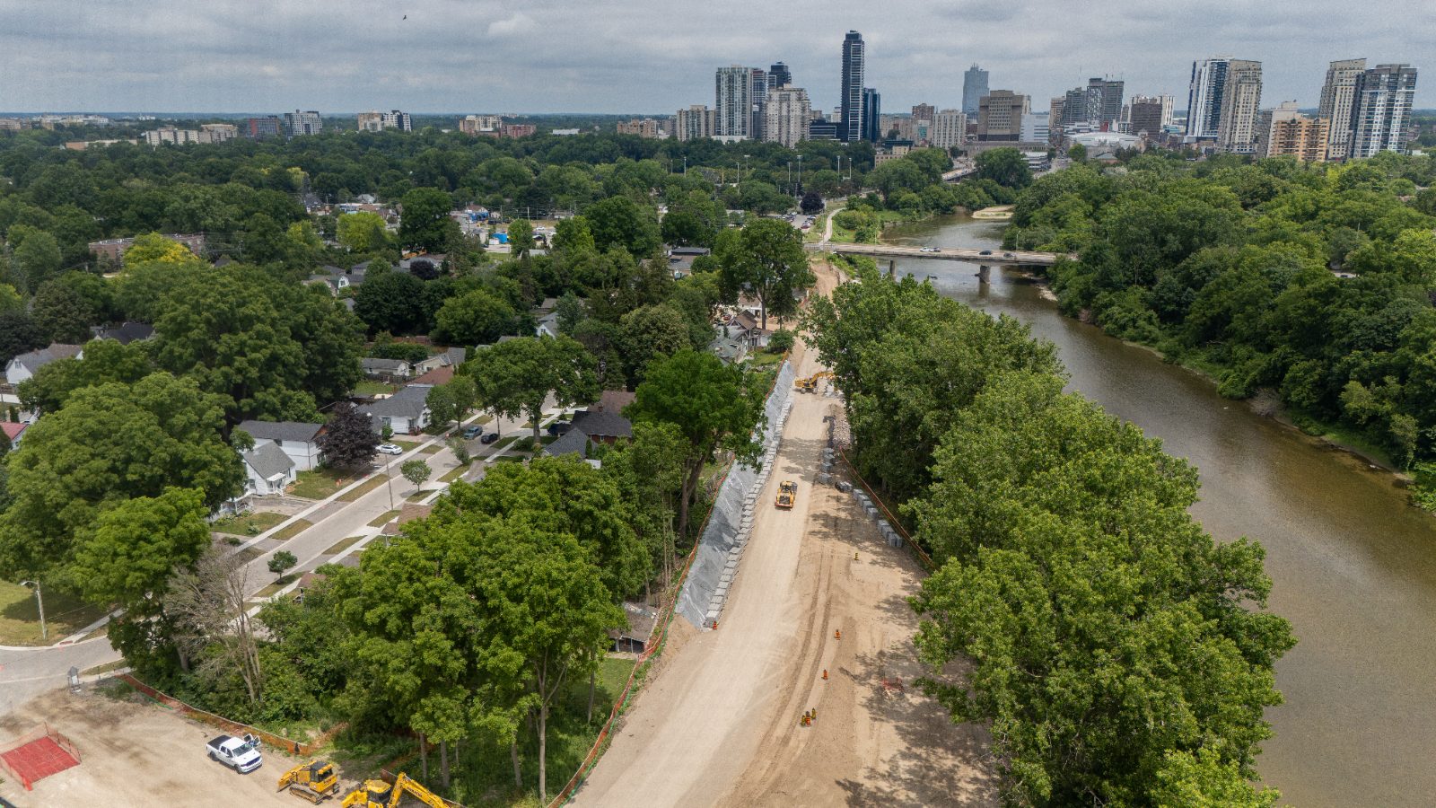 Active dyke wall construction along the Thames River with the downtown London skyline in the background