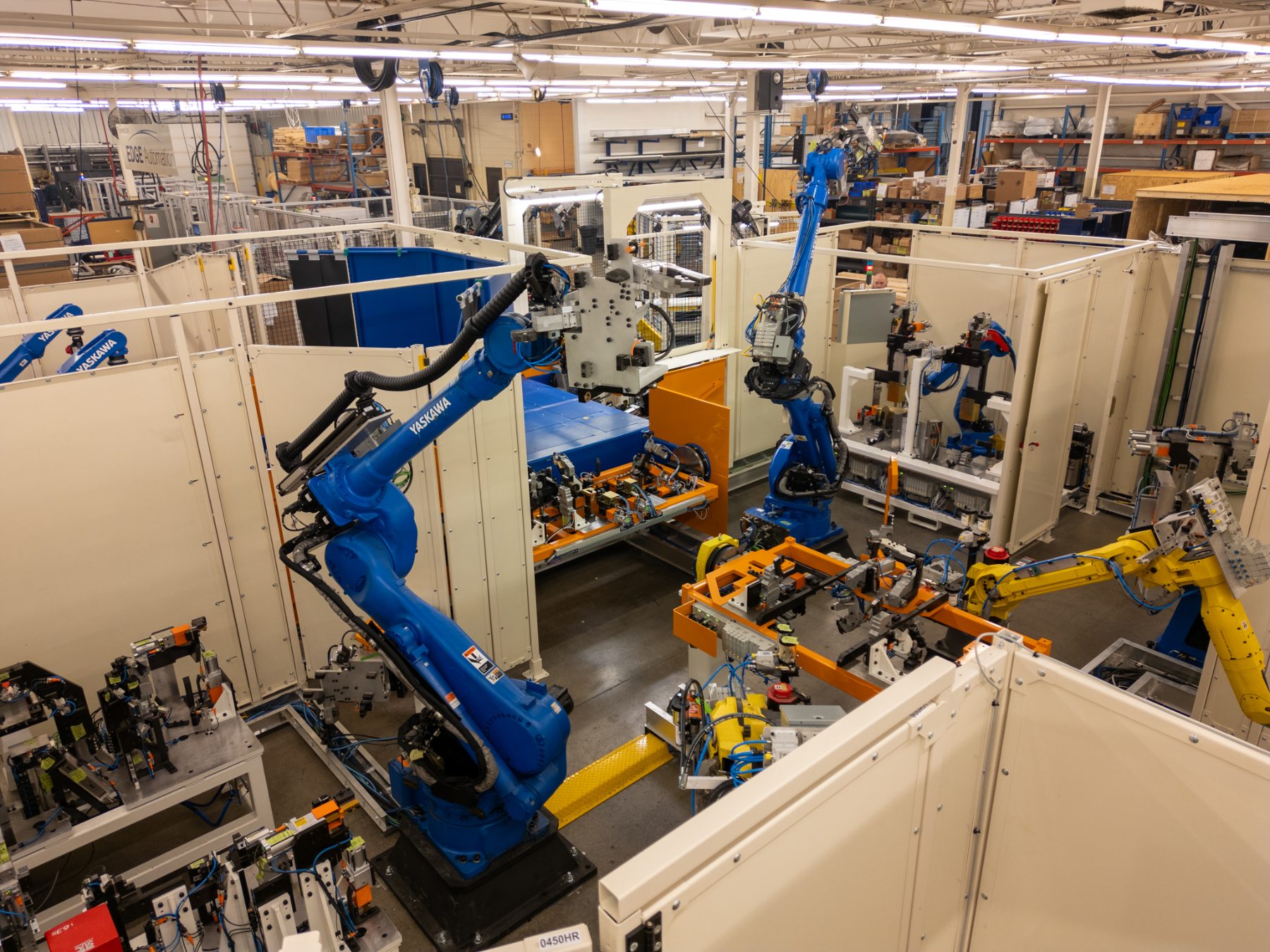 Multiple Yaskawa and Fanuc robotic arms operating in automation cells on the EDGE Automation plant floor