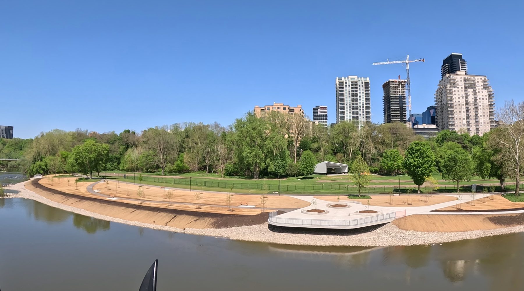 Harris Park shoreline after restoration, showing the reinforced vegetated revetment with native plantings along the Thames River.